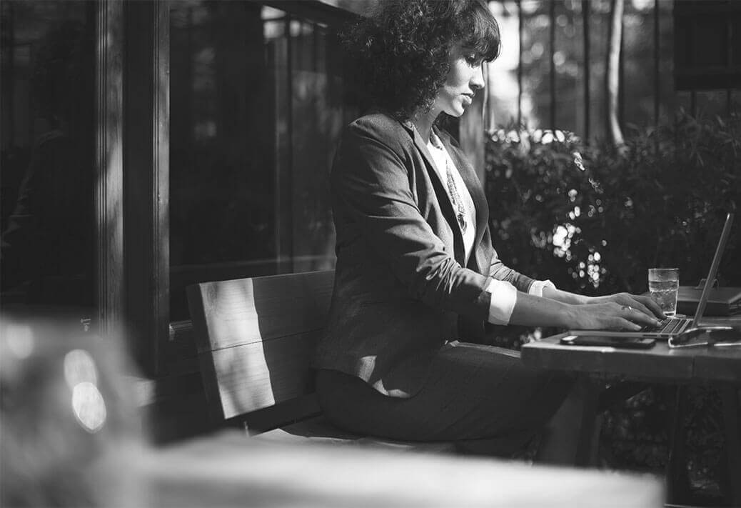 A professional working on a laptop at an outdoor table
