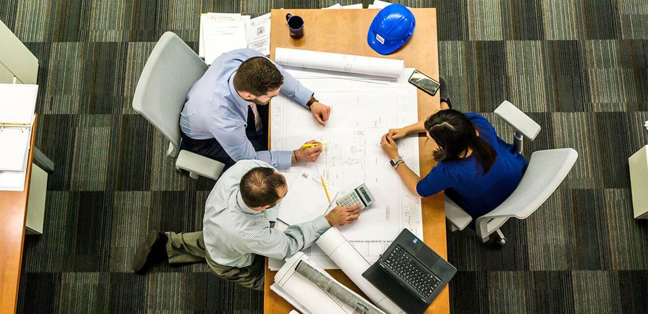 Colleagues reviewing architectural plans at a meeting table