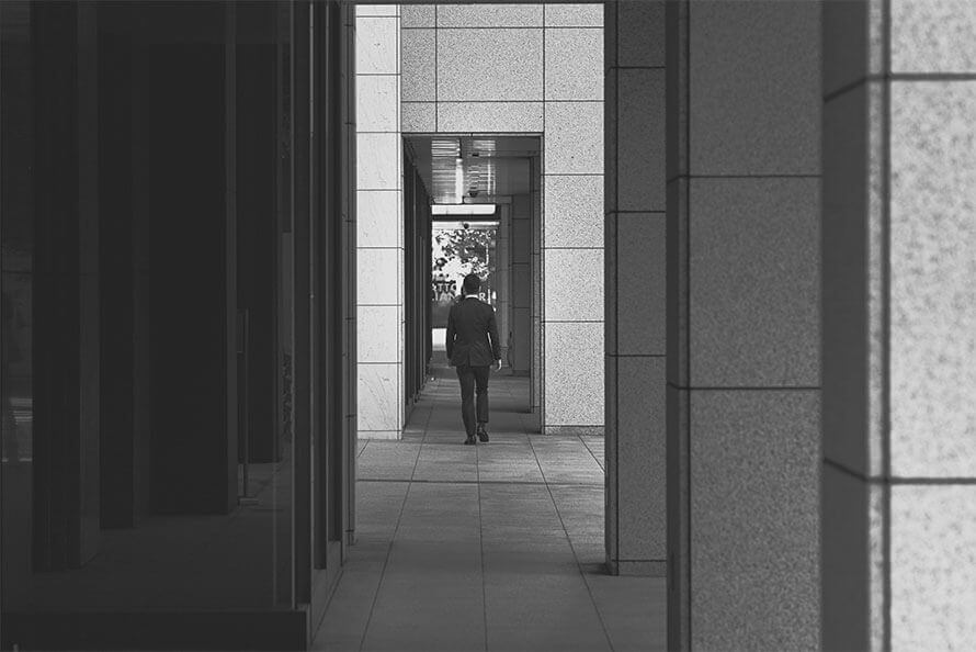 A professional walking through a modern office corridor